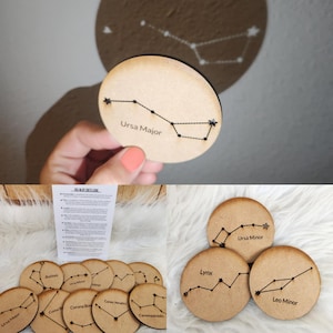 May include: Wooden constellation coasters featuring the Ursa Major, Ursa Minor, Lynx, and Leo Minor constellations. Each coaster has a unique constellation design with star details and text labels. The coasters are round and made of light-colored wood.