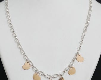 May include: A silver chain necklace with five gold heart-shaped charms hanging from it.