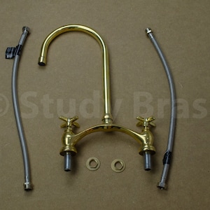 以下が含まれることがあります： 2つのハンドルと高アーチの注ぎ口が付いたゴールド調のキッチン蛇口。蛇口には、フレキシブルホース2本とワッシャー2個が付属しています。