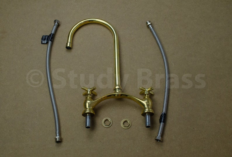 以下が含まれることがあります： 2つのハンドルと高アーチの注ぎ口が付いたゴールド調のキッチン蛇口。蛇口には、フレキシブルホース2本とワッシャー2個が付属しています。