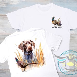 May include: White t-shirt with a brown and white pheasant illustration and the text "Pheasant Hunter". The back of the shirt features a brown and white German Shorthaired Pointer dog with a pheasant in the foreground.