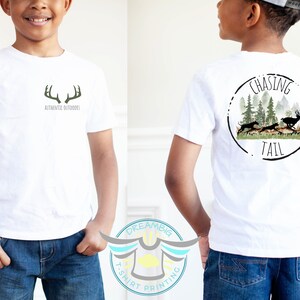 May include: White t-shirt with a green antler design on the front and a circular design with the text "Chasing Tail" and a silhouette of deer in a forest on the back.