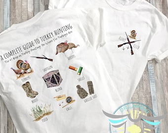 Op de afbeelding: Een wit T-shirt met een grafisch ontwerp van een gids voor kalkoenjacht. De grafiek bevat illustraties van kalkoenen, een jachtgeweer, lokvogels, een schuilplaats, patronen, laarzen, oproepen, een veld en een ghillie-pak. De tekst op het shirt luidt "A Complete Guide to Turkey Hunting. The #1 Rule in Turkey Hunting: Go Where the Turkeys Are."