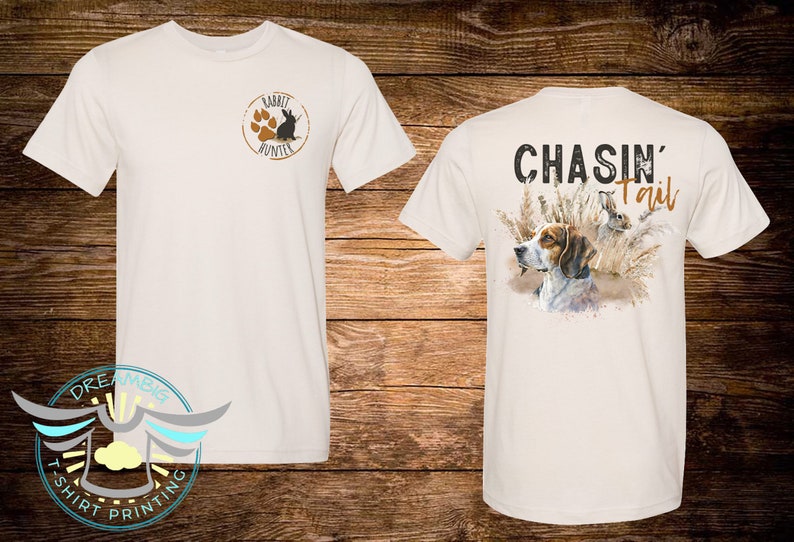 May include: White t-shirt with a brown rabbit hunter logo on the front and the text "CHASIN' Tail" with a brown and white dog and a rabbit in tall grass on the back.