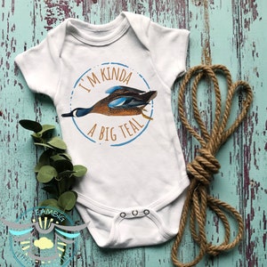 May include: White baby onesie with a blue circle and the text "I'm kinda a big teal" with a teal duck illustration inside the circle.