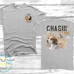 May include: Grey t-shirt with a paw print and rabbit graphic on the front and the text "CHASIN' Tail" with a dog and rabbit graphic on the back.