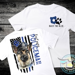 May include: White t-shirts with police-themed graphics. One shirt features a blue badge, paw print, and the text "BACK THE BLUE." The other shirt displays a German Shepherd in a police hat with the text "Future Policeman."