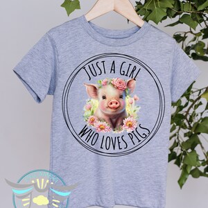 May include: Gray t-shirt with a black circle graphic featuring a pig wearing a pink flower crown and the text "Just a girl who loves pigs".