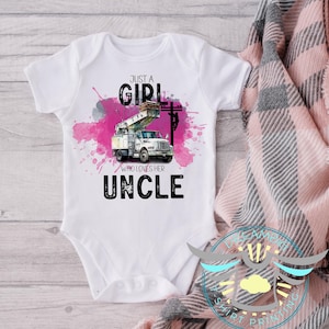 May include: White baby bodysuit with a graphic of a utility truck and the text "JUST A GIRL WHO LOVES HER UNCLE". The design includes pink watercolor splashes and a power line illustration.