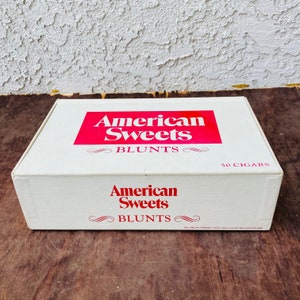 Puede incluir: Una caja blanca con letras rojas que dicen "American Sweets Blunts" y "50 Cigarros".