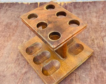 May include: Wooden pipe rack with six round holes on the top shelf and four oval-shaped holes on the bottom shelf.