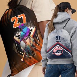 May include: Two drawstring bags with baseball-themed designs. One bag is black with a colorful bird, baseball, and bats. The bag has the number "27" on it. The other bag is gray with a blue, red, and white design. The bag has the number "91" and the text "LEWIS" on it. The bag also has the text "METRO JETS" on it.