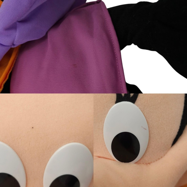 May include: A purple and black plush toy with large white eyes and a black nose. The toy is wearing a purple and orange hat.