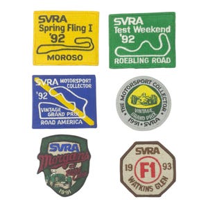 May include: A collection of six embroidered patches featuring the SVRA logo and various race track designs. The patches are in various shapes and colors, including yellow, green, blue, and brown. Each patch includes text indicating the year and location of the event.