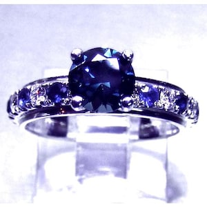 Ladies custom designed 14 karat white gold untreated top Montana VVS blue and teal blue color change  sapphire and diamond  engagement ring