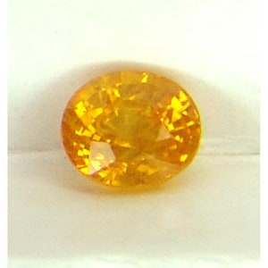 May include: A bright yellow oval-shaped gemstone with facets.