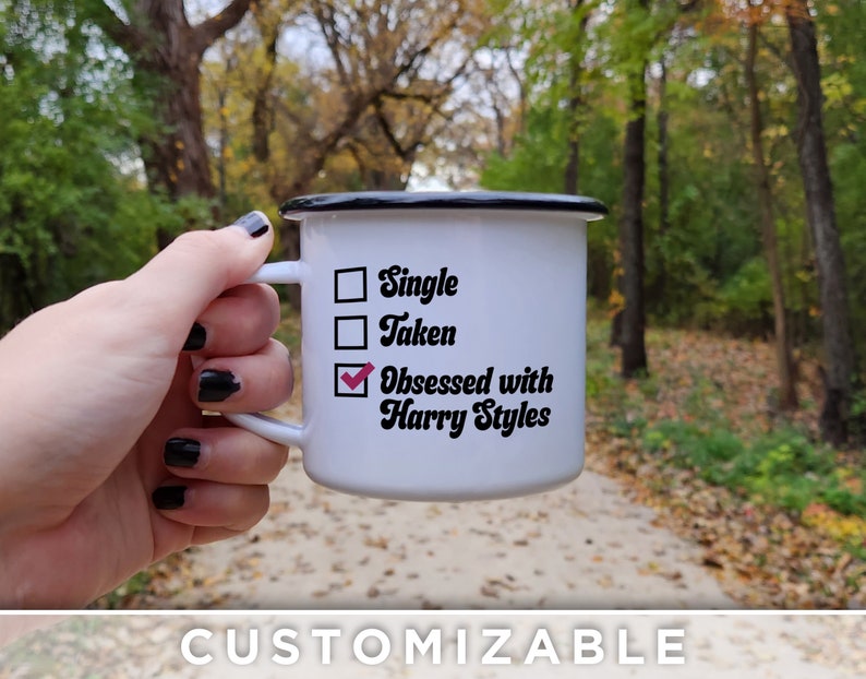 K&ouml;nnte beinhalten: Wei&szlig;e Email Tasse mit schwarzem Rand und Henkel. Die Tasse hat eine Checkliste mit drei Optionen: Single, Taken, Obsessed with Harry Styles. Die dritte Option ist angekreuzt.