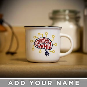 May include: White ceramic mug with a black rim. The mug has a graphic of a brain with the words "Computer Whiz" inside the brain. The brain is connected to a plug with yellow wires.
