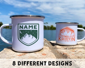 Puede incluir: Dos tazas de camping de esmalte blanco con diseños diferentes. La taza de la izquierda tiene una escena de montaña verde con una luna creciente y estrellas y el texto "NAME". La taza de la derecha tiene una escena de montaña naranja con un sol y el texto "KRISTIN EST. 2021".