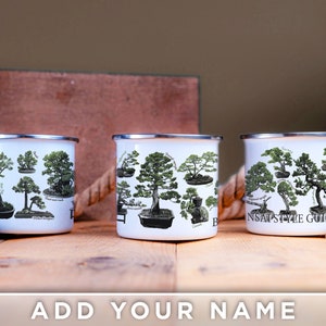 May include: Three white enamel mugs with silver rims and handles. Each mug features a detailed illustration of bonsai trees with labels. The text "Bonsai Style Guide" is visible on one mug. The bottom of the image has the text "ADD YOUR NAME".
