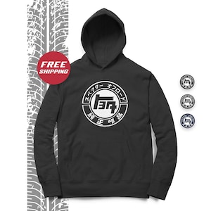 May include: Black hooded sweatshirt with a white circle logo featuring the Toyota logo and Japanese text that reads "Toyota Motor Corporation, Genuine Parts".