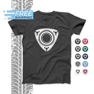 Könnte beinhalten: Ein dunkelgraues T-Shirt mit einer weißen Grafik eines Rotationsmotors. Die Grafik ist eine stilisierte Darstellung eines Rotationsmotors, einer Art Verbrennungsmotor. Das T-Shirt ist in verschiedenen Farben erhältlich, darunter Rot, Grün, Blau, Grau und Pink.