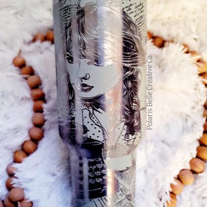 Puede incluir: Vaso de acero inoxidable con un retrato grabado de una mujer. El retrato est&aacute; rodeado de escritura y elementos de dise&ntilde;o. El vaso tiene una pajita transparente y las palabras "Polaris Belle Creative Co." est&aacute;n impresas en el lateral.