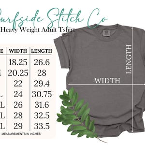 May include: A gray heavy-weight adult t-shirt with size, width, and length measurements in inches. The t-shirt has a crew neck and short sleeves. The text "Surfside Stitch Co" is at the top of the image.
