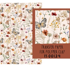 Op de afbeelding: Een vel transferpapier voor polymer clay met een bloemenpatroon met vlinders, bloemen en grassen in tinten bruin, geel en roze. De tekst "TRANSFER PAPER FOR POLYMER CLAY TS 00124" is op het papier gedrukt.