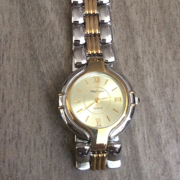 Oleg Cassini Women's Two Tone Watch Having a Round Gold Dial Roman Numerals & Index Hours on Two Tone Linked Band Rare un-used New Vintage.