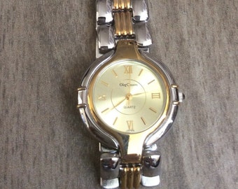 Oleg Cassini Women's Two Tone Watch Having a Round Gold Dial Roman Numerals & Index Hours on Two Tone Linked Band Rare un-used New Vintage.