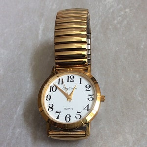 Oleg Cassini Gold Women's Watch Round White Dial with Easy to Read Black Arabic Numbered Hours Gold Stretch Band Vintage Mint Condition Rare