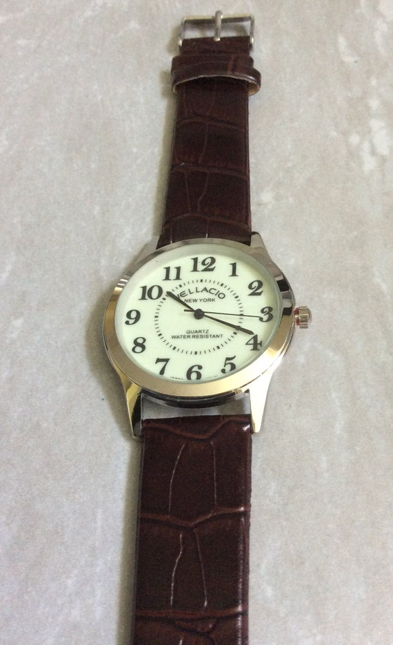 Vellaccio Reloj plateado para hombre Esfera redonda que brilla en la oscuridad Horas numeradas en negro Correa marron Reloj nuevo vintage sin usar