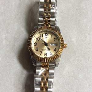 MONTRES CARLO Damenuhr Rundes goldenes Zifferblatt Schwarz nummeriert Stunden Tag & Datum auf einem zweifarbigen verknüpften Band Neue Unbenutzte Vintage Uhr WR 5ATM!