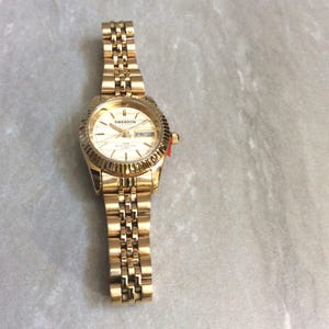 SWANSON GOLD Damenuhr Rundes Gold akzentuiertes Zifferblatt Index Stunden Tag & Datum auf Gold Linked Band Unbenutzte neue Vintage Uhr Schönheit!