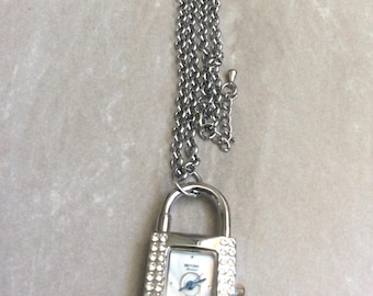 Collana vintage con lucchetto di cristallo, quadrante rettangolare con perle, ore a indici, lancette blu, catena da 16 pollici, ancora nuova, mai usata, perfettamente funzionante.
