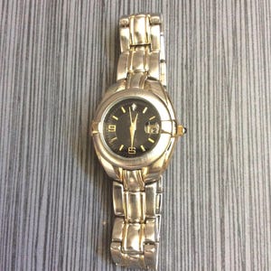 Reloj John Weitz para mujer de dos tonos, esfera negra redonda con indicador de fecha en una correa de dos tonos unida. Reloj vintage sin usar. ¡Nuevo/antiguo stock!