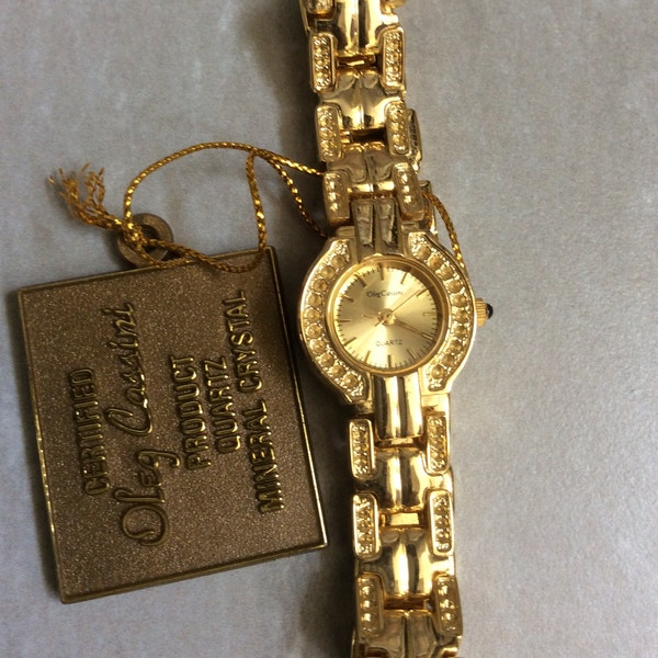 Oleg Cassini Women's gold watch round gold dial on matching linked band rare find vintage watch in new condition.