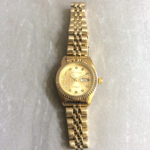 Reloj MIYKON Dorado con Esfera Redonda Dorada con Fecha y Cristales para las Horas en una Correa de Eslabones Dorados. Nuevo Reloj Vintage Sin Usar. ¡Verdadera Belleza!