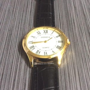 Geneva Men&#39;s Watch Gold Case Round White Dial Black Roman Numeral Hours on Black Leather Band New Unused Vintage Watch!