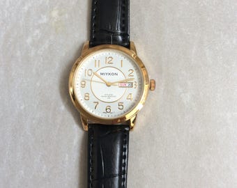 Relógio masculino MIYKON Gold redondo, branco, com mostrador de dia e data, horas numeradas em ouro e pulseira de couro preta. Relógio vintage novo, sem uso, avaliado em 30MWR!