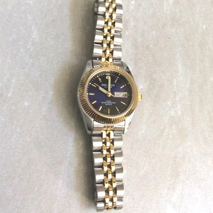 SWANSON Damenuhr mit einem runden blauen Zifferblatt Gold Index Stunden Tag & Datum Anzeige auf zweifarbigen Linked Band Unbenutzte Vintage New Watch Beauty