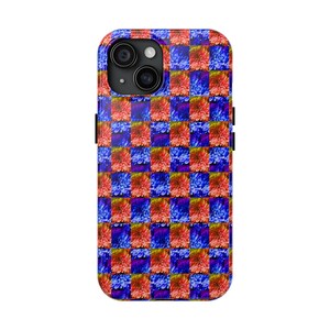 Könnte beinhalten: Eine Smartphone-Hülle mit einem sich wiederholenden Schachbrettmuster aus leuchtend orange-roten Dahlienblüten, die sich mit tiefblauen und violetten Blumenquadraten abwechseln. Das Design bedeckt die gesamte Rückseite, einschließlich des Kameraausschnitts.