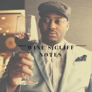 Może przedstawiać: Mężczyzna w szarym garniturze i czapce trzyma szklankę czerwonego wina. Na zdjęciu widnieje tekst "Wine's Cliff Notes".