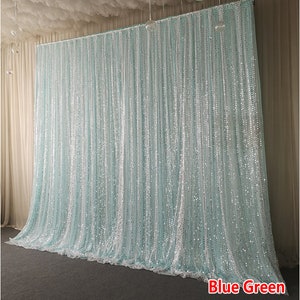 Op de afbeelding: Een blauwgroene, glinsterende achtergrond met pailletten. De achtergrond is gemaakt van transparante stof en is perfect voor een bruiloft, feest of andere speciale gelegenheden.