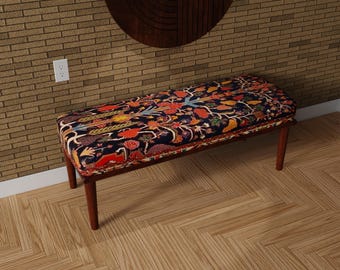 May include: A decorative bench with a dark wood frame and legs. The seat features a colorful floral pattern on a navy blue background. The bench is approximately 48 inches long.