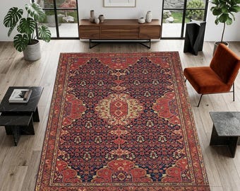 May include: A large, rectangular Persian-style rug with a detailed floral pattern in shades of red, navy blue, and cream. The rug is the focal point of a living room, with a wooden cabinet, chair, and side tables.