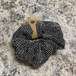 May include: A black hair scrunchie with silver glitter dots.
