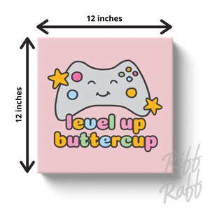 May include: A 12-inch square canvas print with a pink background. It features a smiling gray video game controller with colorful buttons and star accents. The text "level up buttercup" is below the controller.