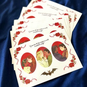 May include: A white sticker sheet featuring three oval illustrations of couples in intimate poses, framed by red floral vines. The text "If you were the last vampire on earth, it would be enough." is printed above the ovals, with a small brown bat below.